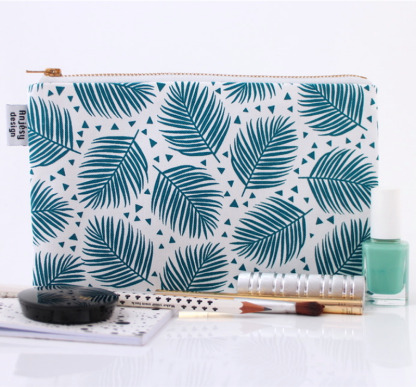 Une pochette blanche avec des motifs feuillages bleus.