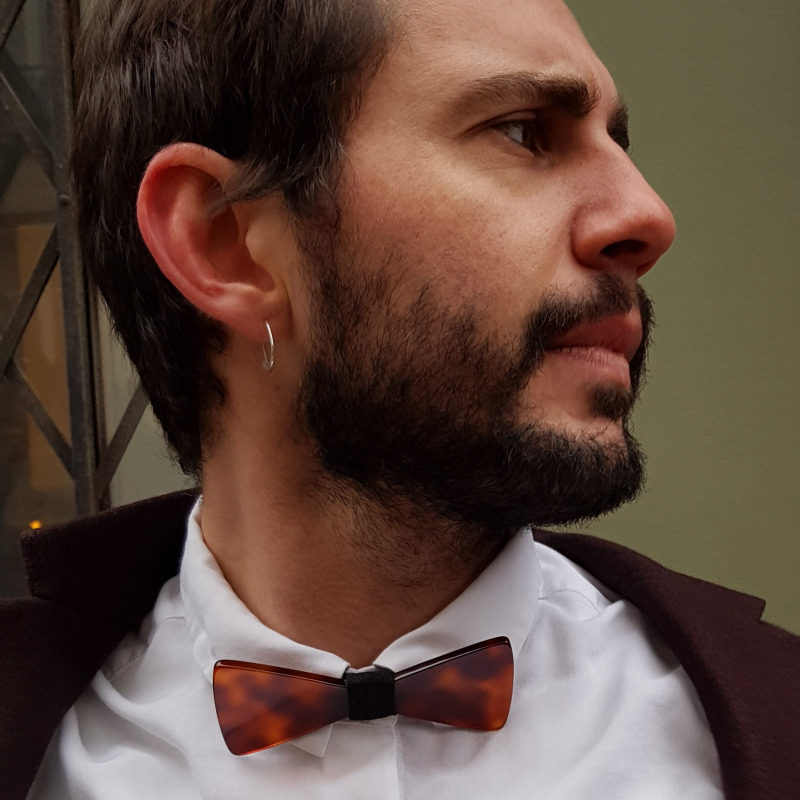 Un homme qui porte un nœud papillon en plastique marron.