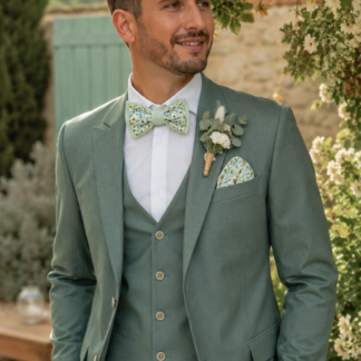 marié élégant avec costume vert qui porte un noeud papillon vert clair pour mariage pastel avec costume vert