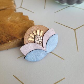 Broche fleur solaire en cuir réemployé ciel rose et beige et rayons en plaqué or
